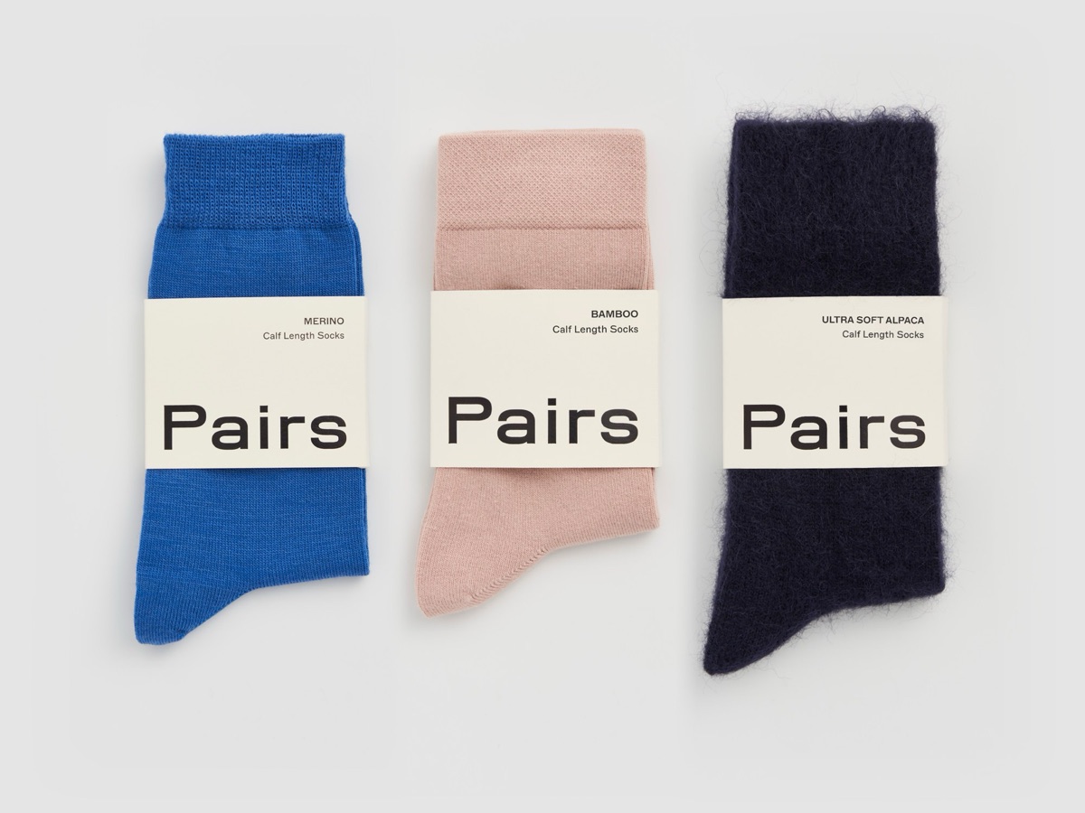 Three folded Pairs socks in their sleeves: blue merino, dusky pink bamboo and navy ultra soft alpaca